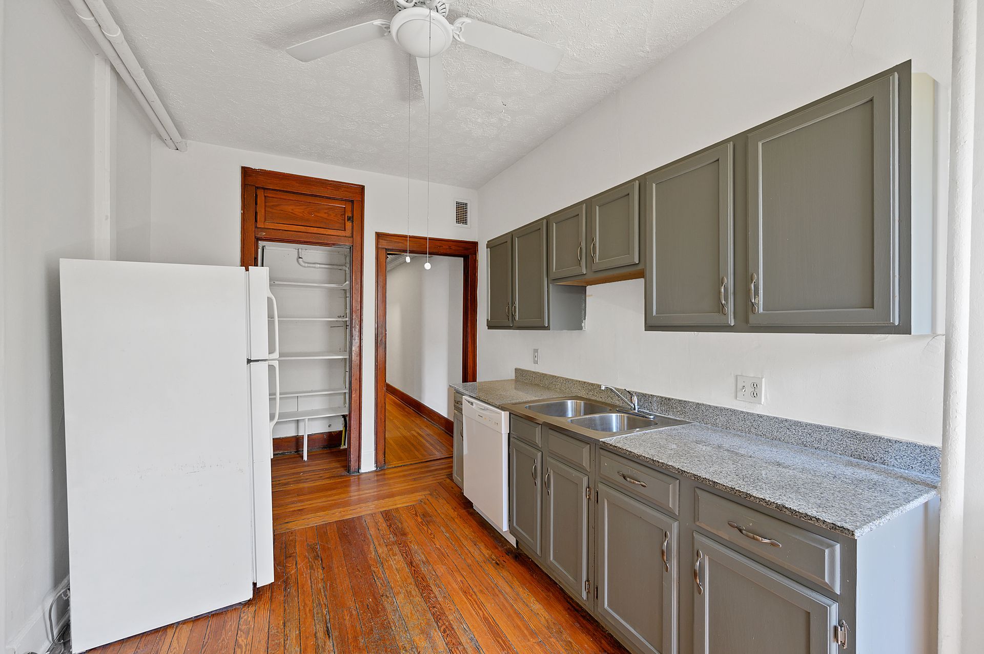 A kitchen with gray cabinets and a white refrigerator