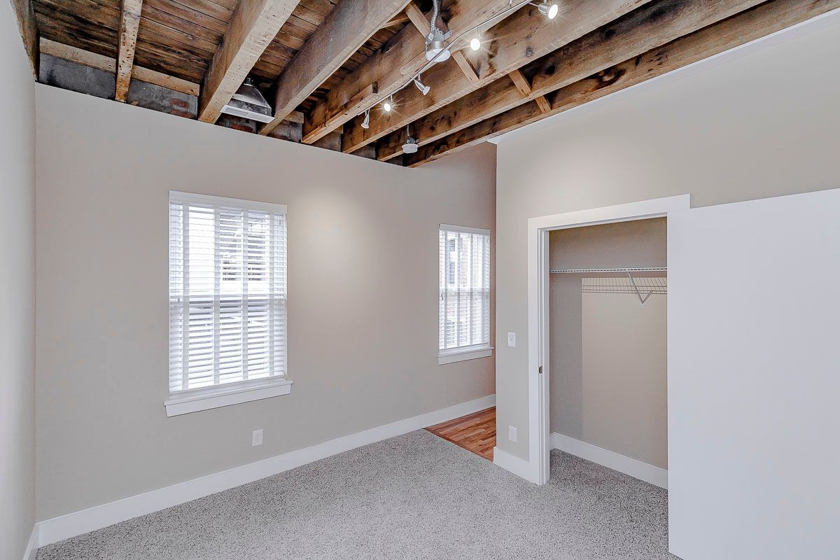 An empty bedroom with a closet and a window.