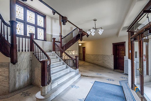 A hallway with stairs leading up to the second floor of a building.