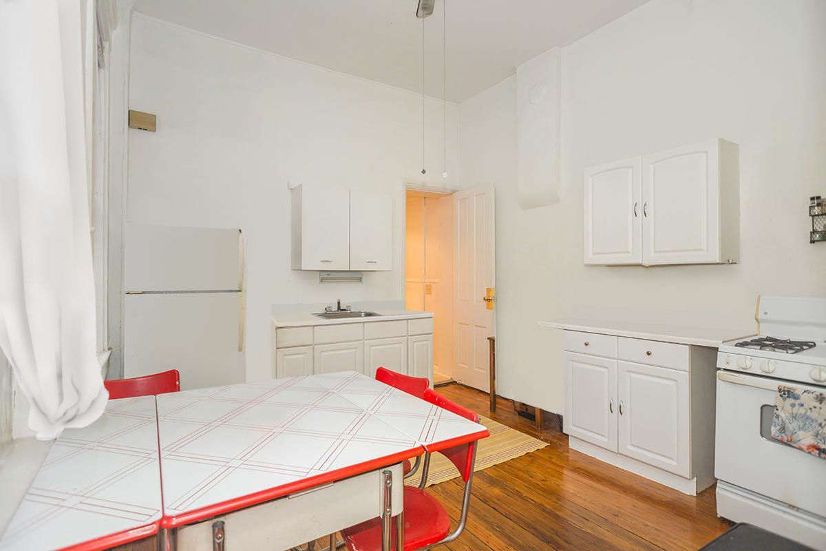 A kitchen with a table and chairs and a stove.
