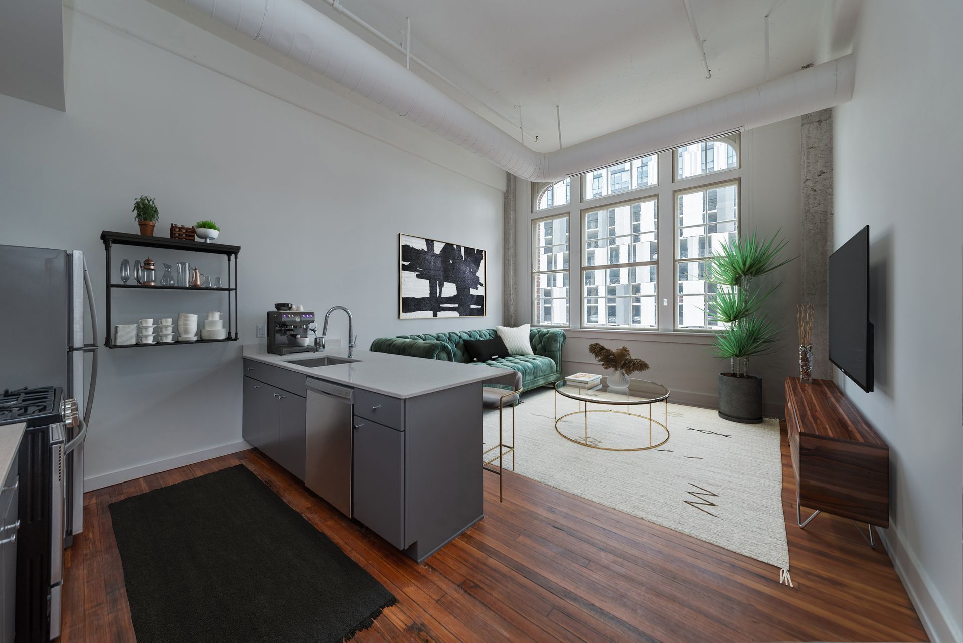 A kitchen with a stainless steel refrigerator and a couch