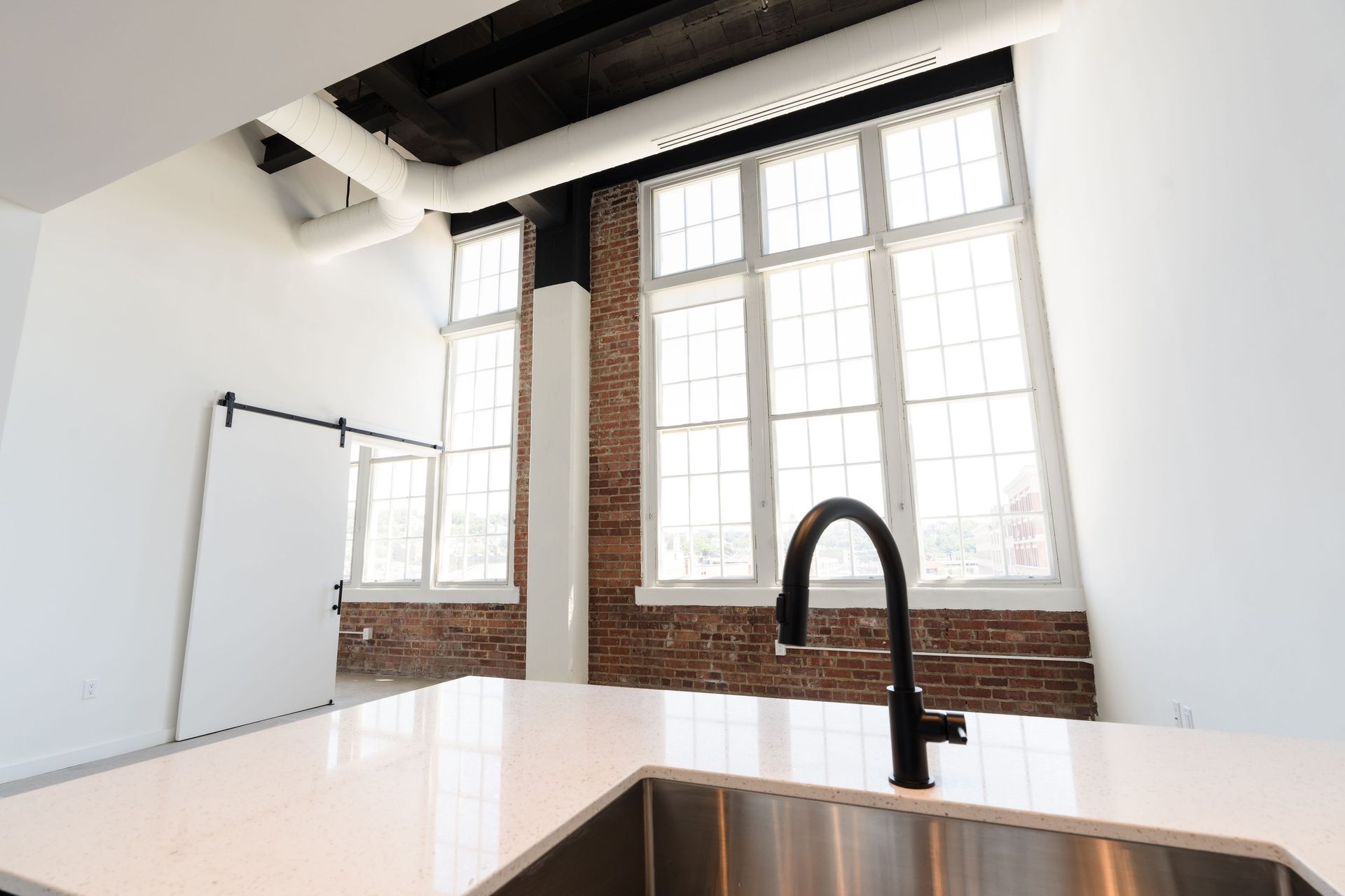 A kitchen with a stainless steel sink and a large window.