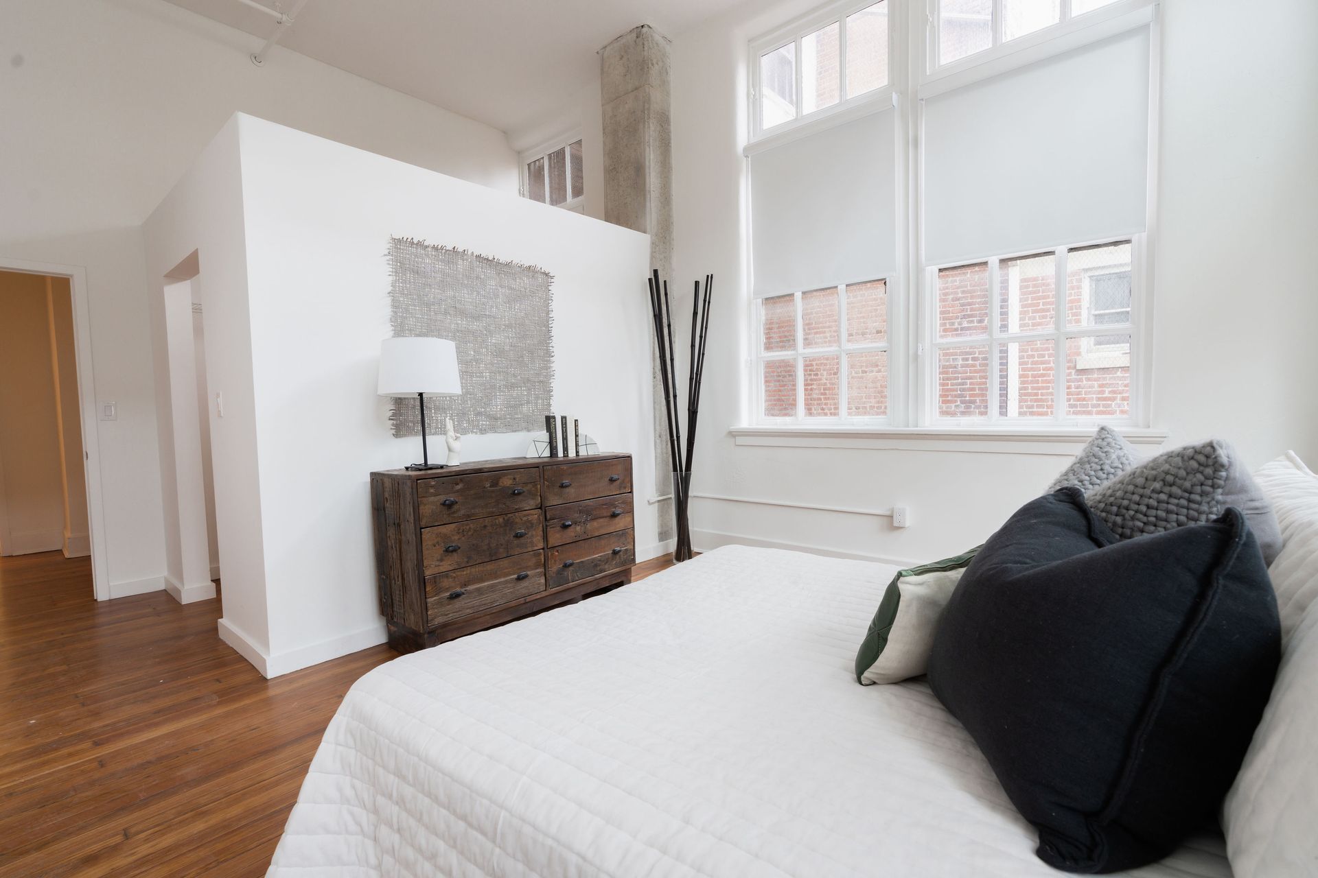 A bedroom with a bed , dresser , and window.