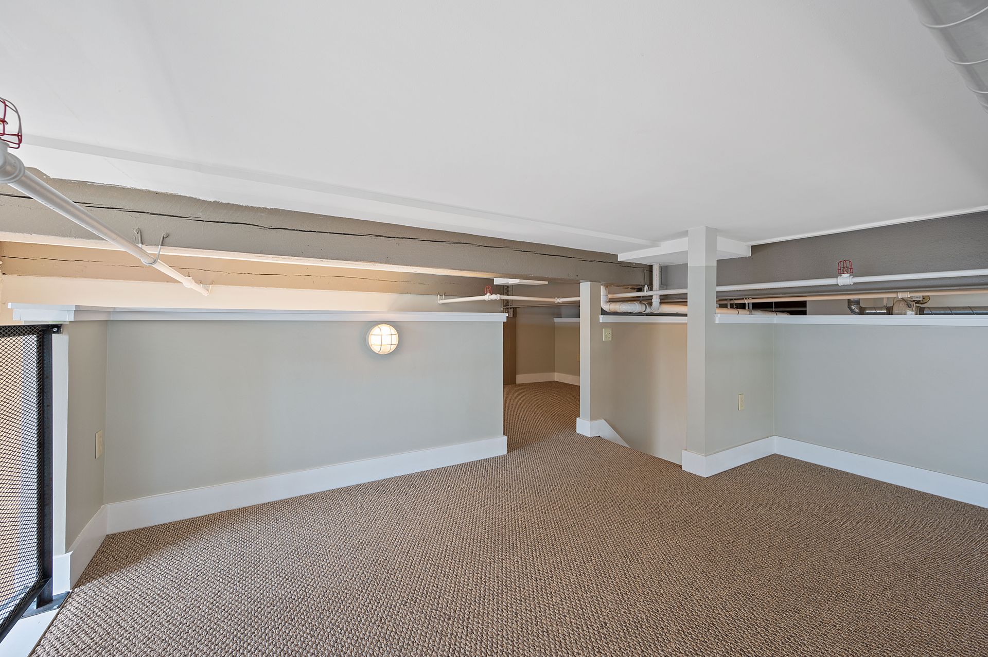 An empty room with a carpeted floor and a balcony.
