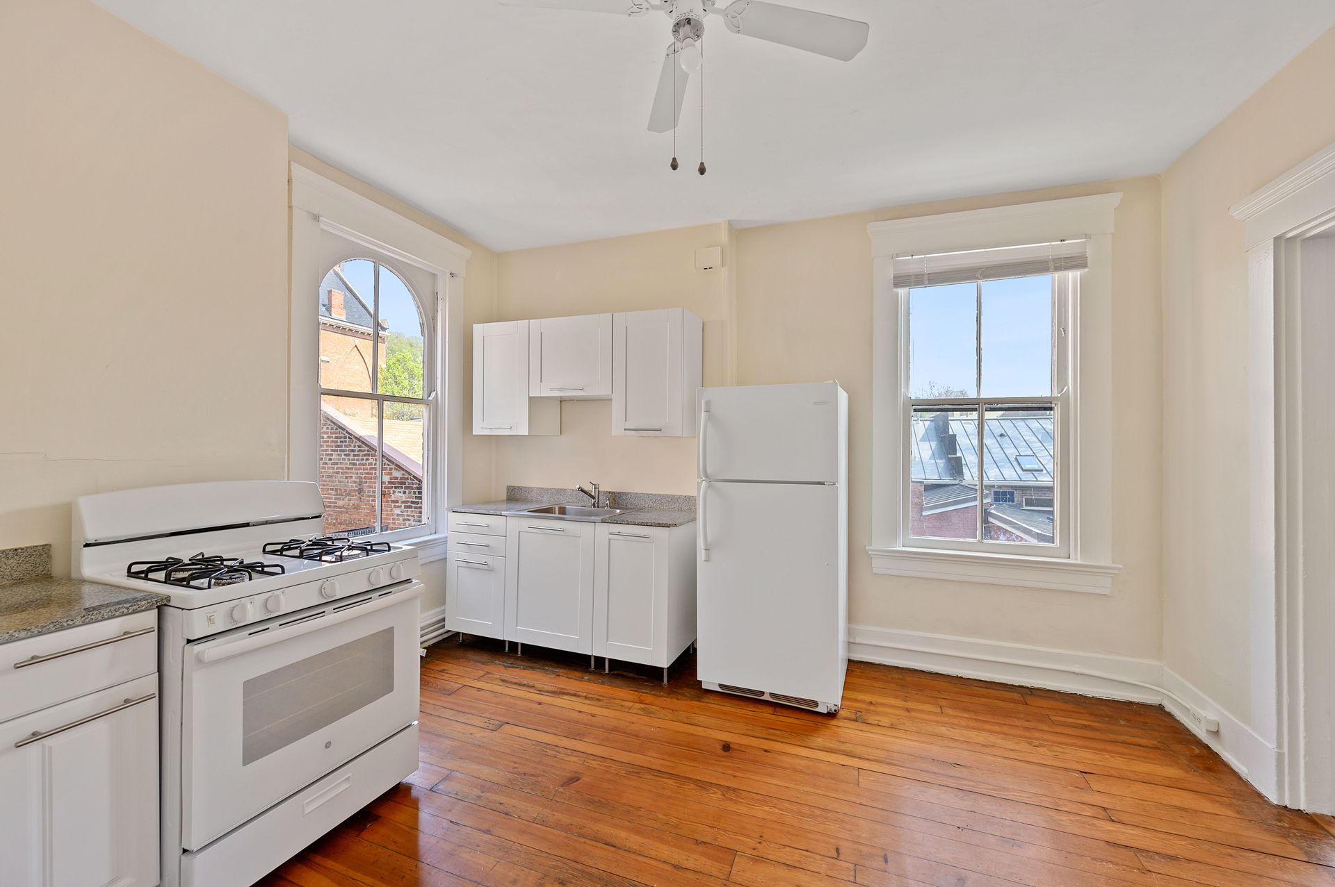 A kitchen with white cabinets and a white refrigerator