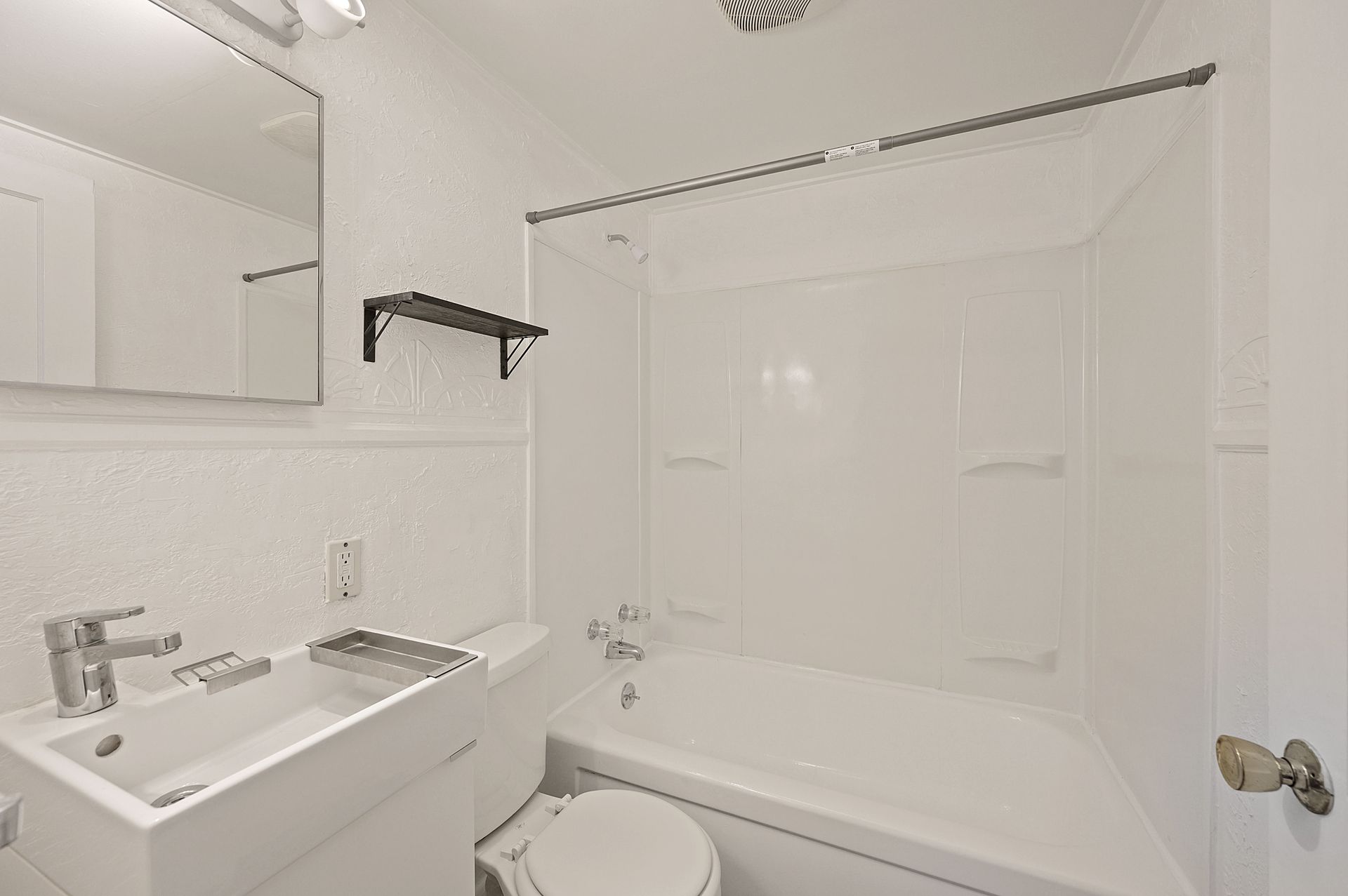 A bathroom with a sink , toilet , bathtub and mirror.