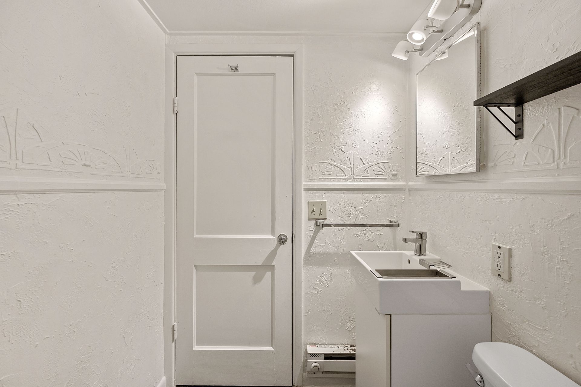A bathroom with a sink , toilet and mirror.