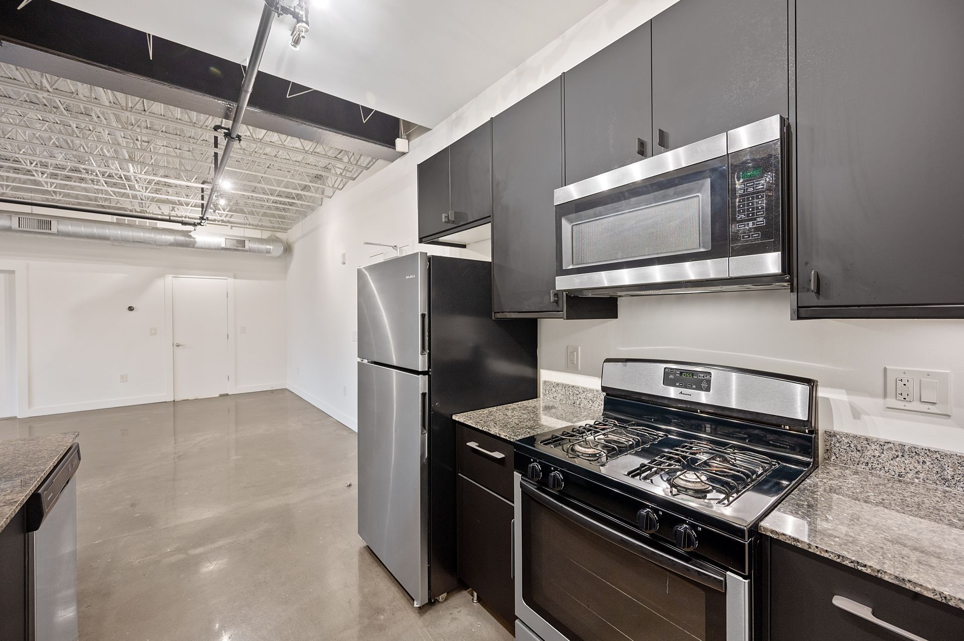 A kitchen with stainless steel appliances and black cabinets