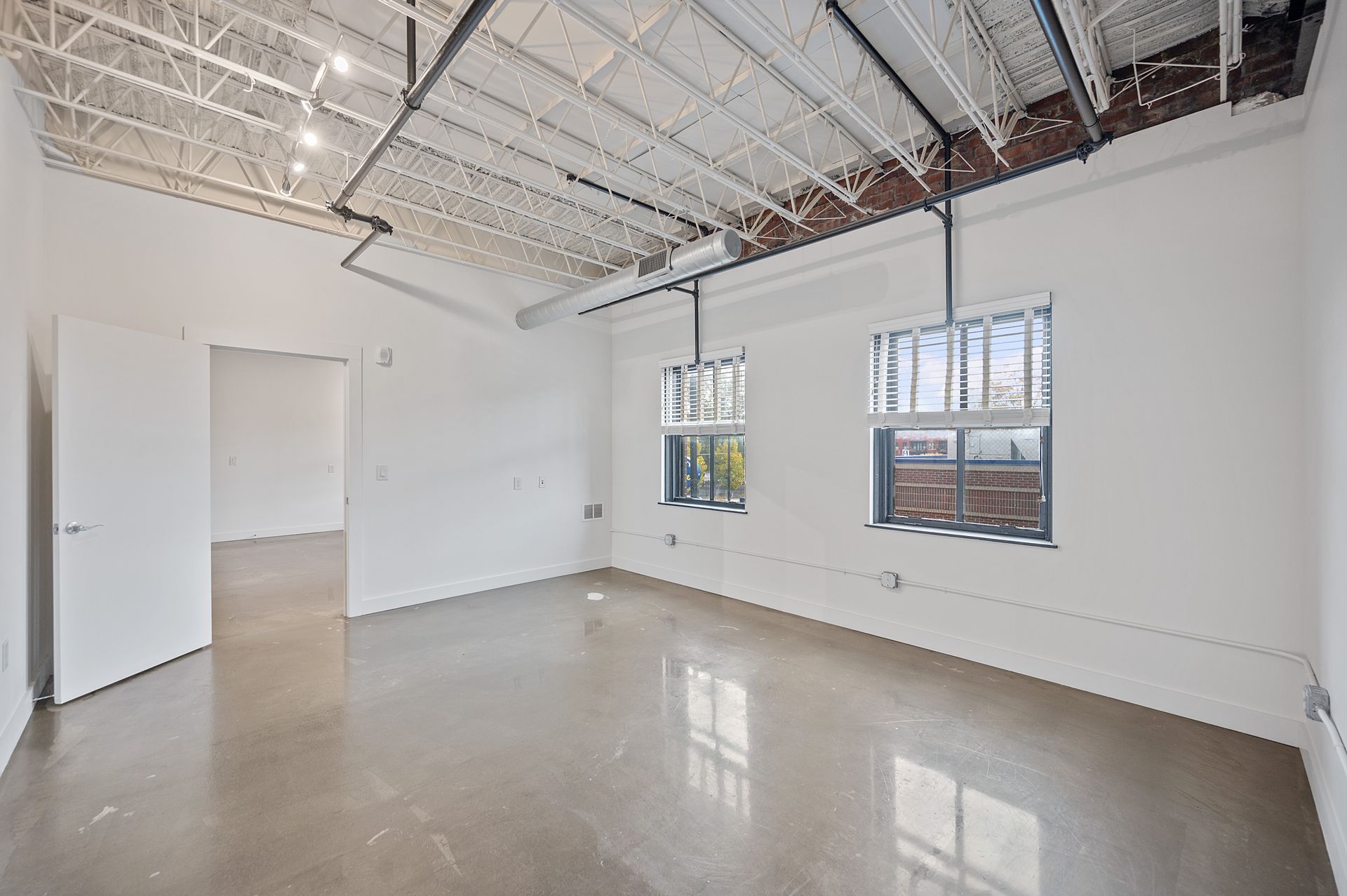 An empty room with two windows and a ceiling.