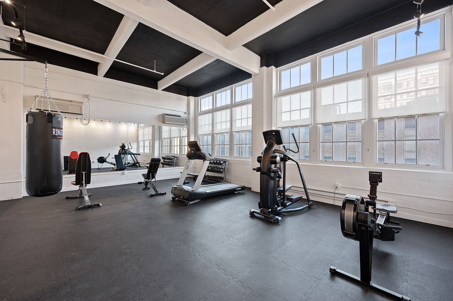 A gym with a lot of windows and exercise equipment