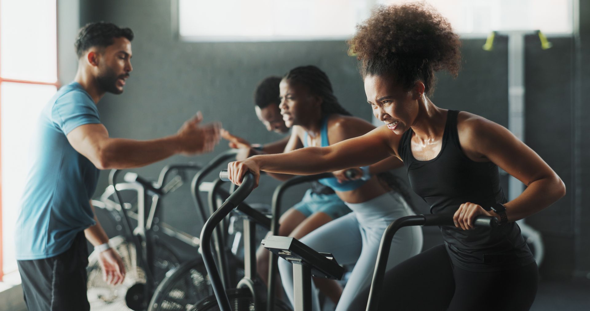 A group of people are riding exercise bikes in a gym.