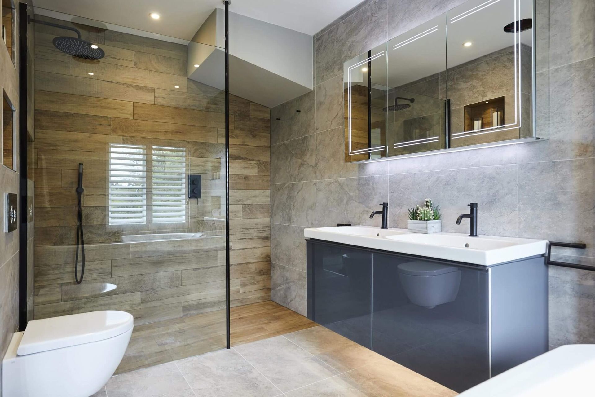 A bathroom with two sinks , a toilet , and a walk in shower.