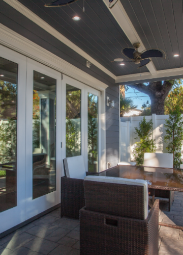 A patio with a table and chairs and a ceiling fan