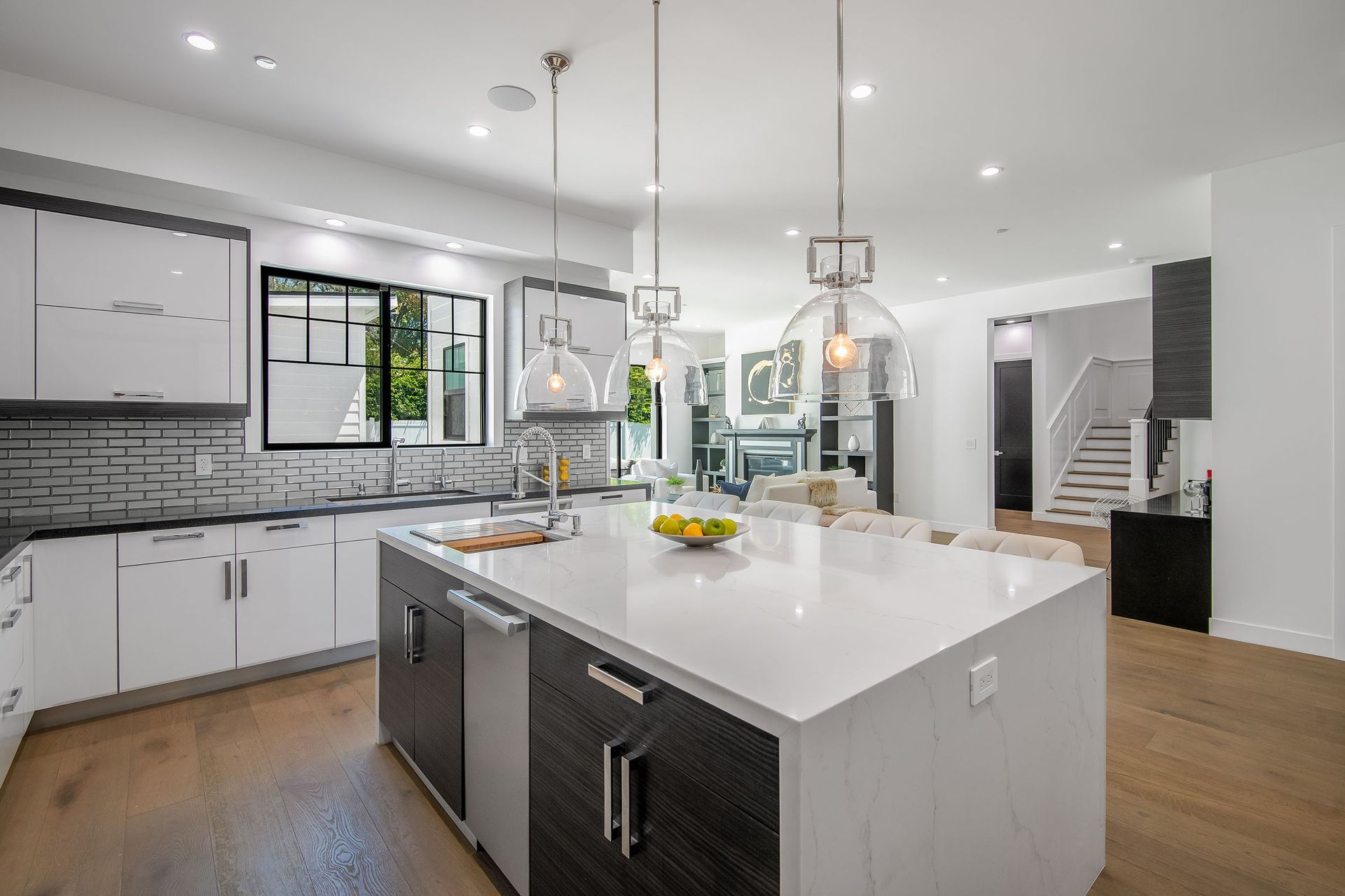 A kitchen with white cabinets and a large island in the middle.
