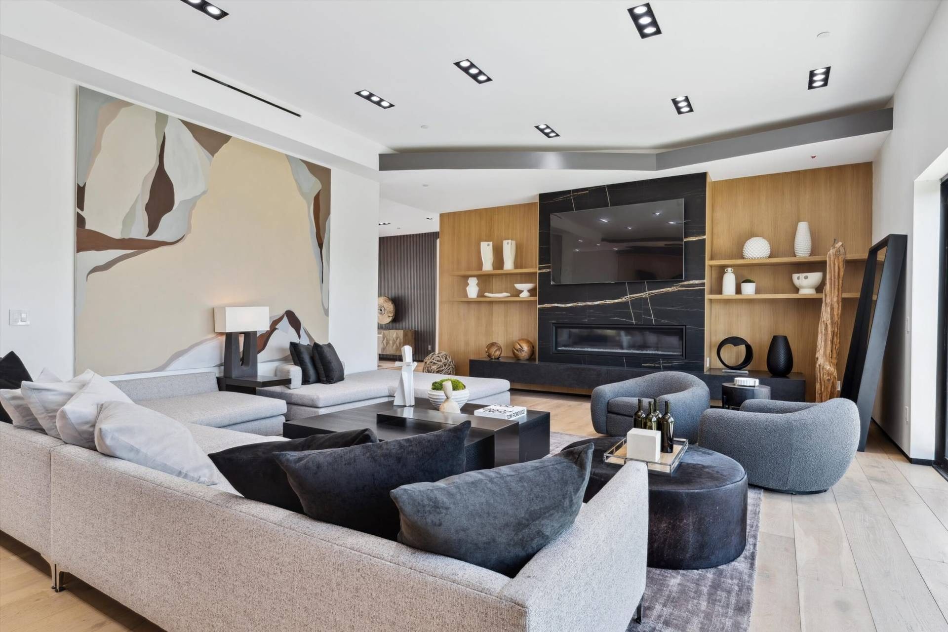 A living room with a couch , chairs , tables and a fireplace.