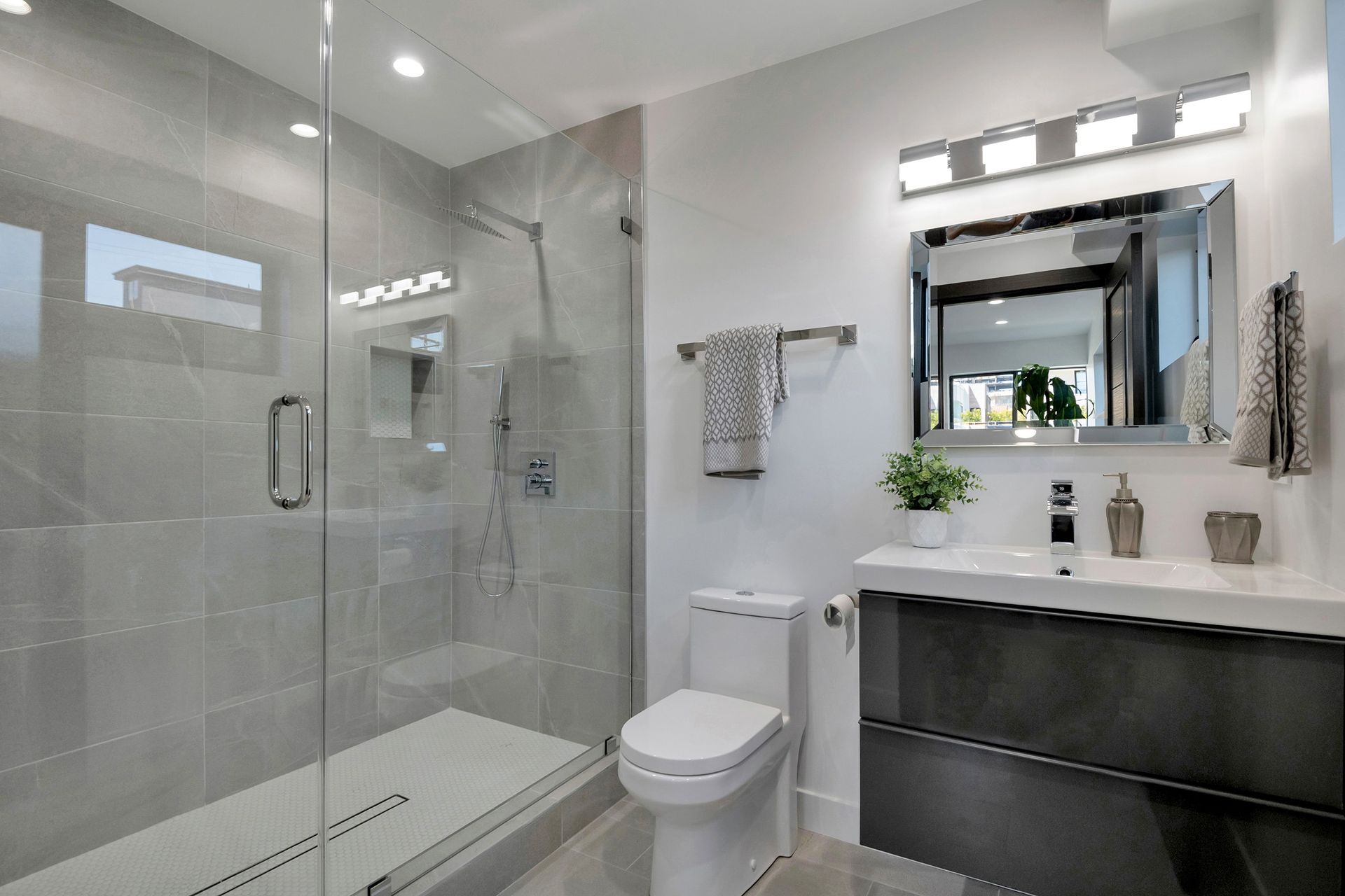 A bathroom with a toilet , sink and walk in shower.