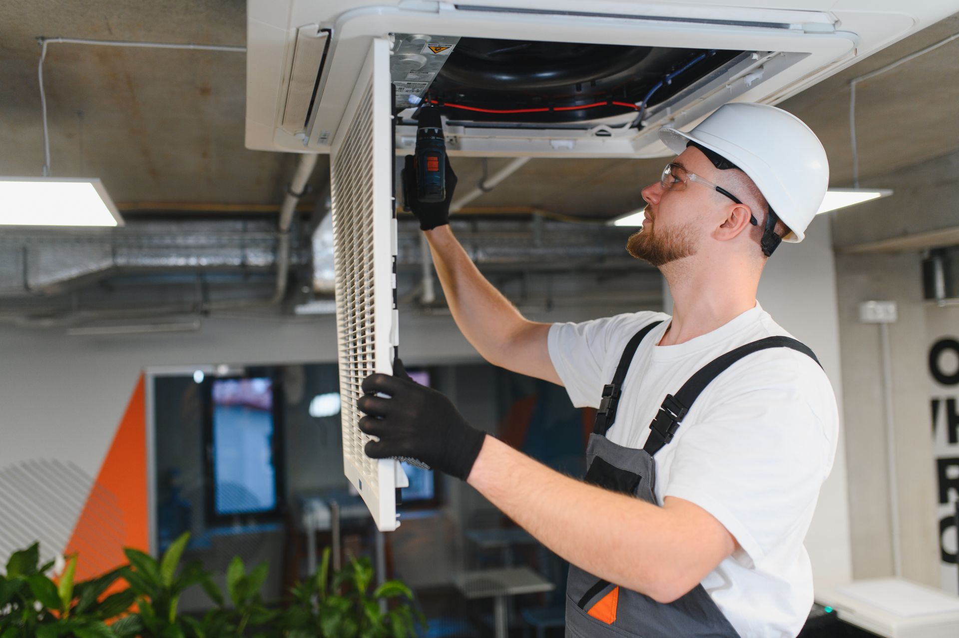 HVAC technician servicing a commercial air conditioning system in an office building. HVAC technician servicing a commercial air conditioning system in an office building.