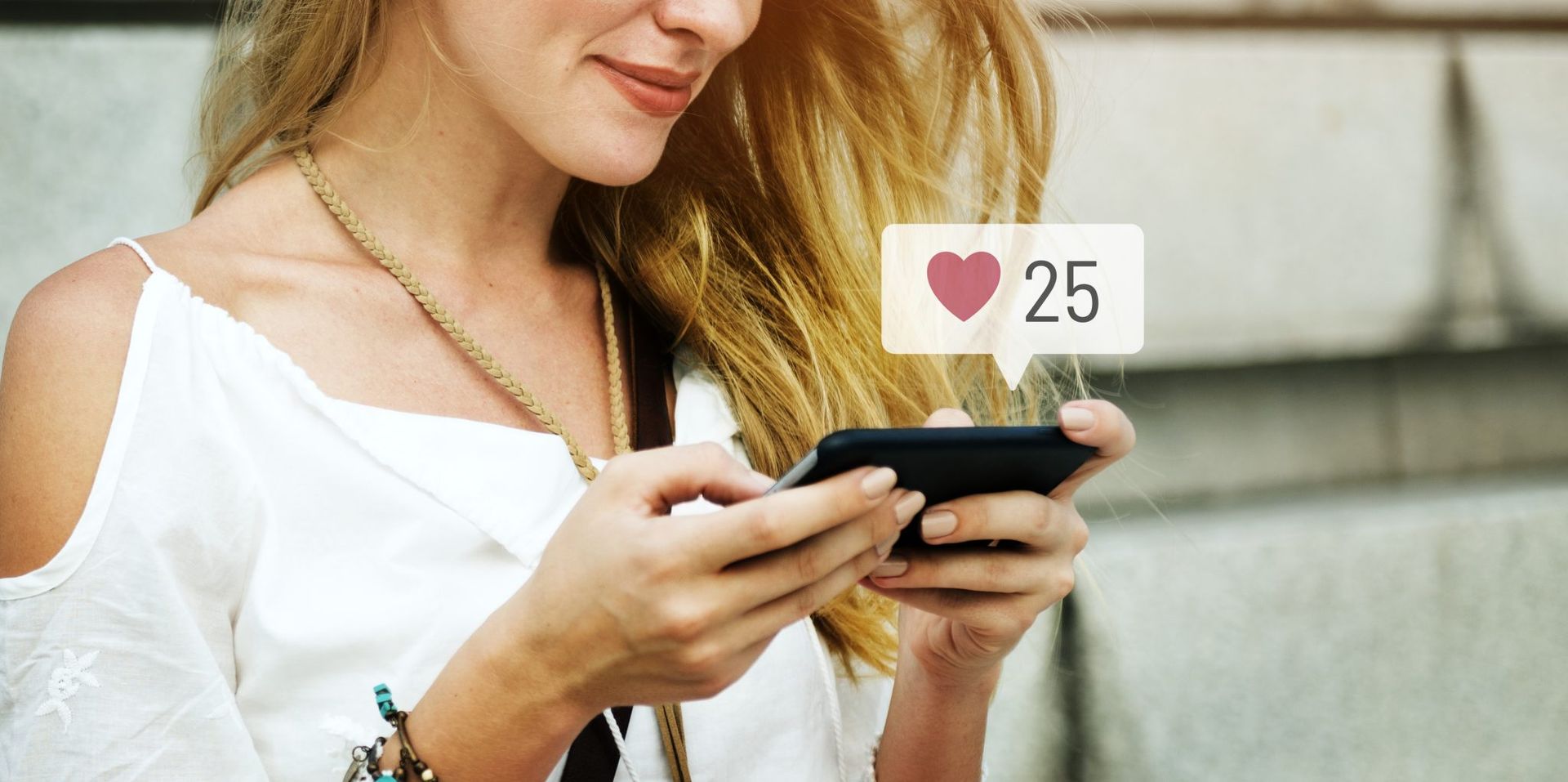 Una mujer está usando un teléfono celular con un ícono de corazón en él.