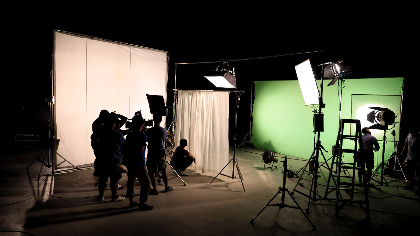 A group of people are standing in front of a green screen.