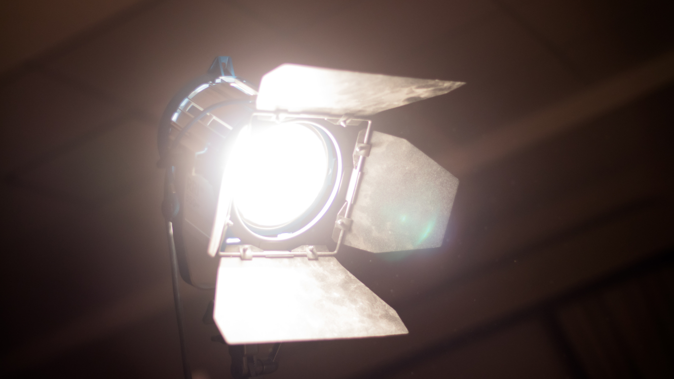 A spotlight is shining brightly in a dark room.