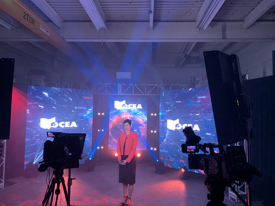 A woman is standing in front of a large screen that says cia