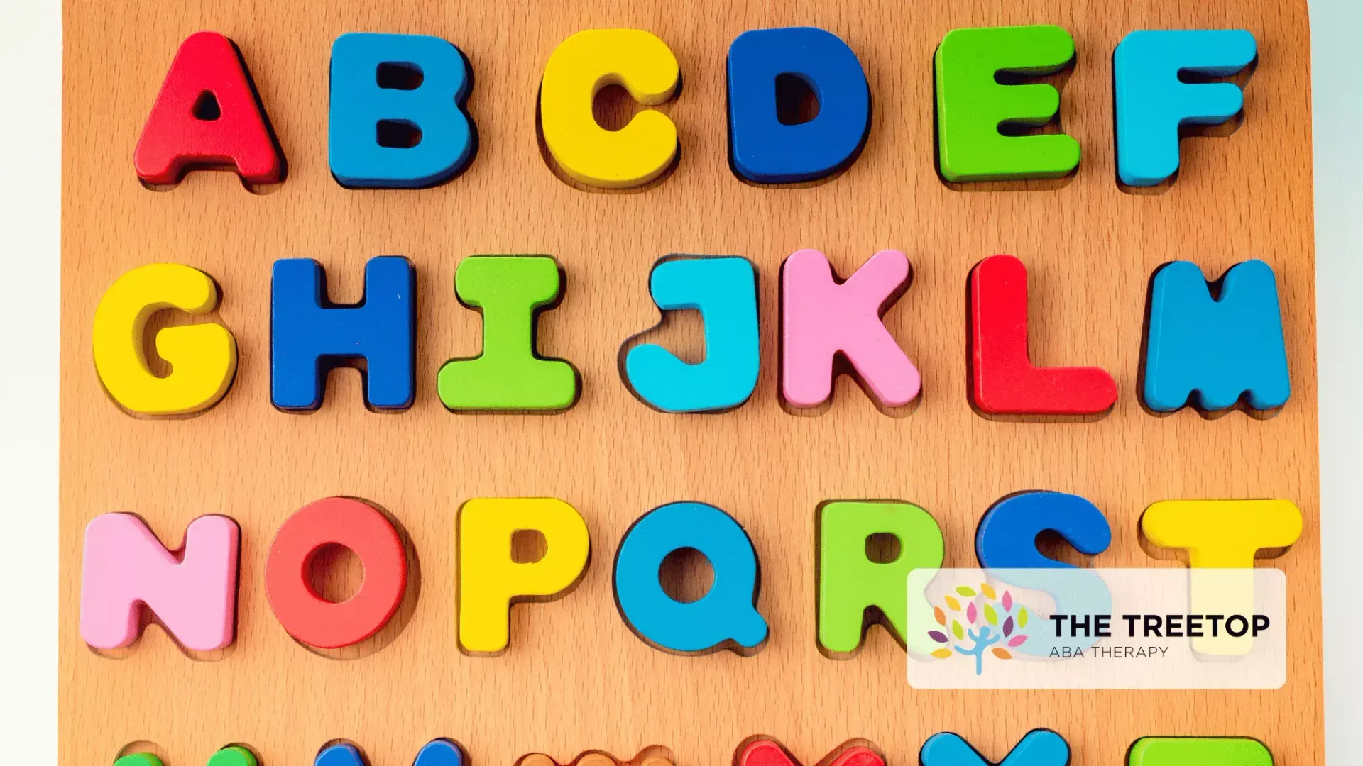 A wooden puzzle board featuring colorful, raised English alphabet letters arranged in rows.