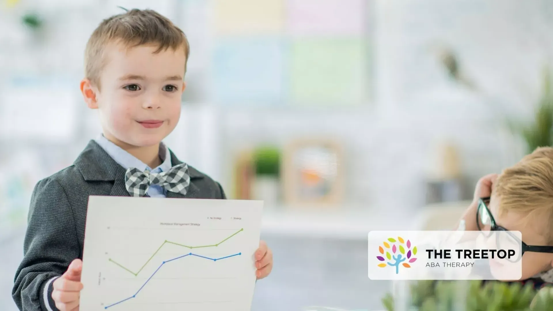 Child holding a chart in a bright classroom, presenting a rising line graph