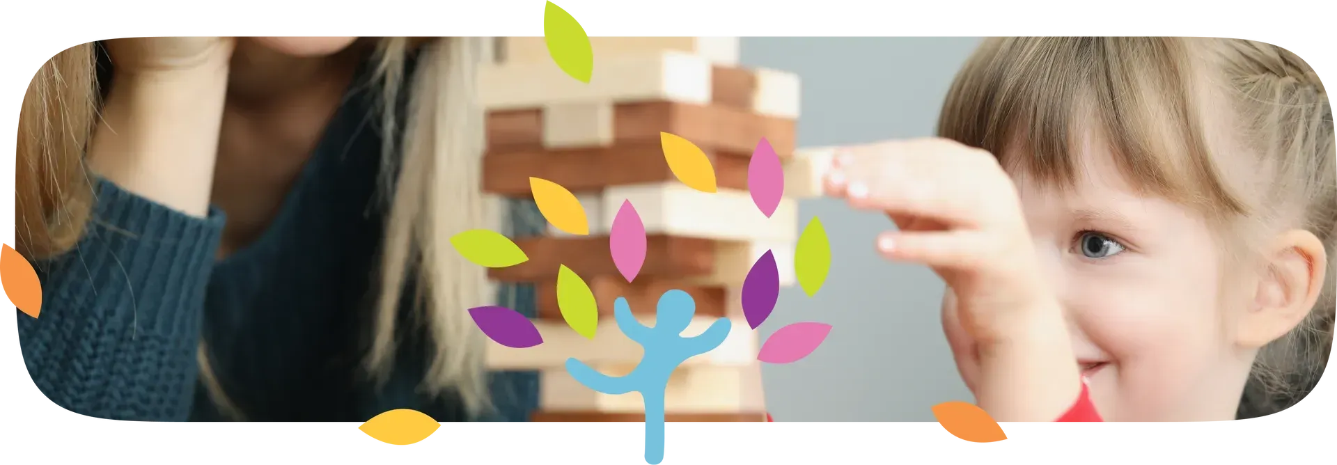 A child focuses on removing a wooden block from a Jenga tower, with a person sitting nearby and a colorful leaf icon.