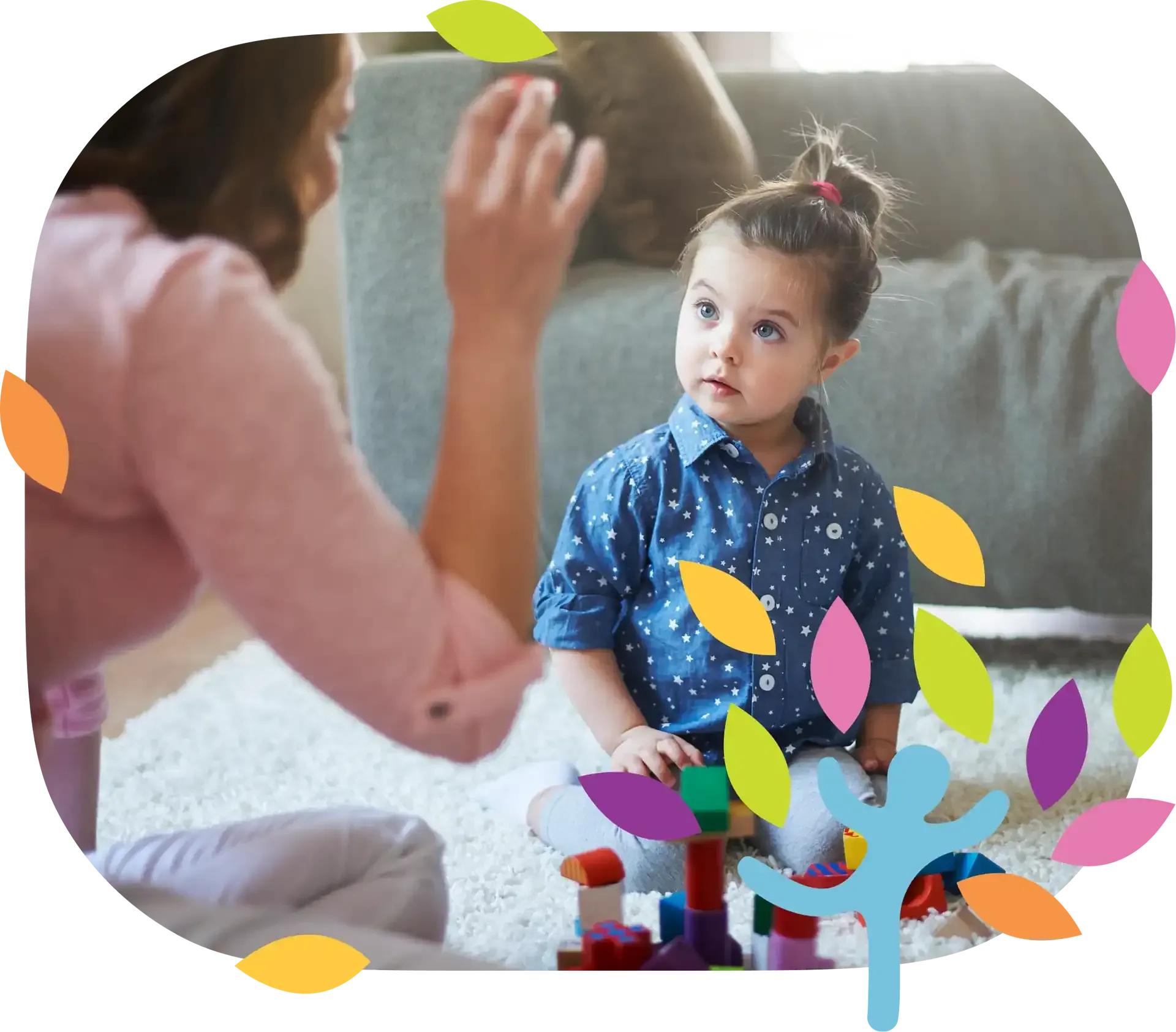 A person interacts with a child playing with colorful building blocks on a rug in a bright, indoor setting.