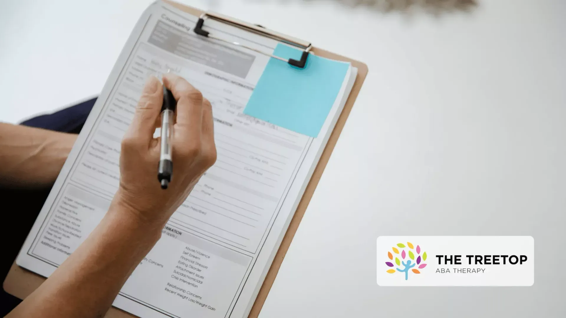 A hand holds a pen and fills out a form on a clipboard next to a Treetop Therapy logo.
