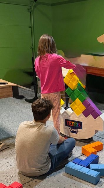 A swimming pool in a desert landscape with lounge chairs, umbrellas, and colorful beanbag chairs on a concrete deck.