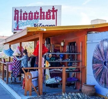 A cream-colored logo for the Joshua Tree Music Festival featuring wings, a heart, a star, and the text 