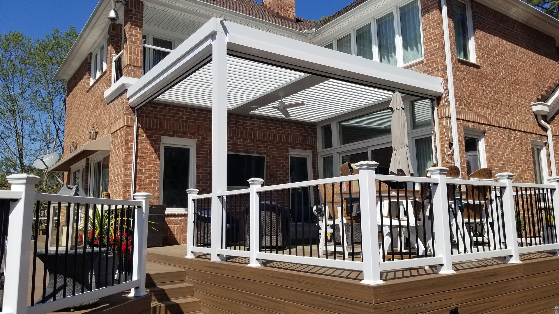 A large brick house with a large deck with a pergola.