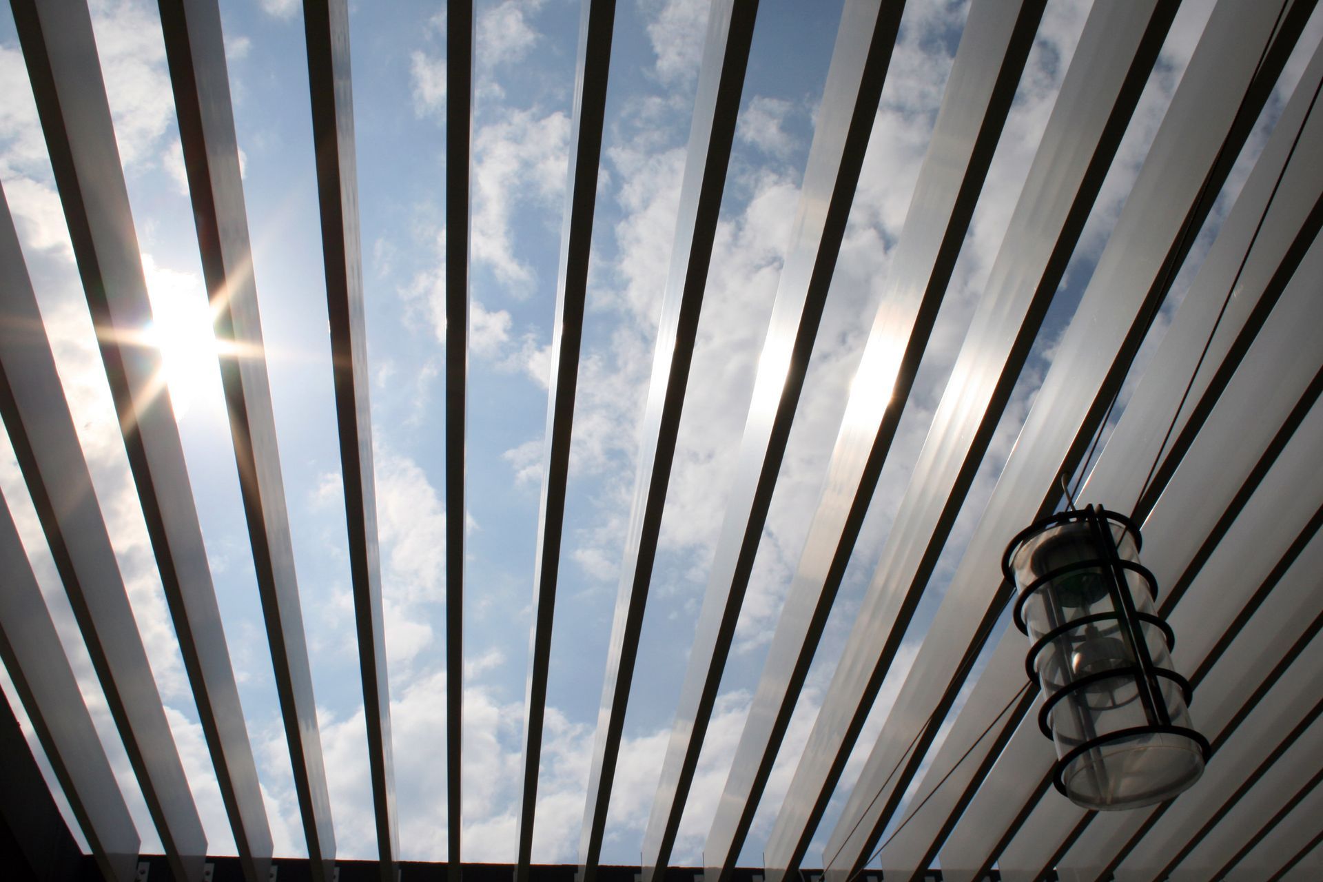 Struxure Pergolas with sleek beams and open slats under blue sky, showcasing modern outdoor design. Struxure Pergolas with sleek beams and open slats under blue sky, showcasing modern outdoor design.