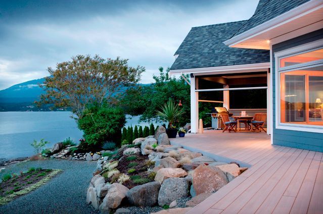 A house with a large deck overlooking a lake.