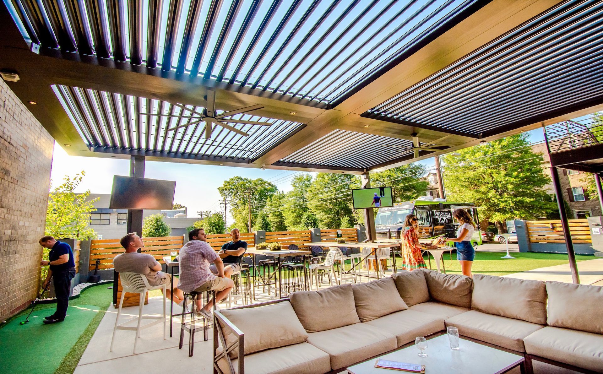 A group of people are sitting on a couch under a canopy.