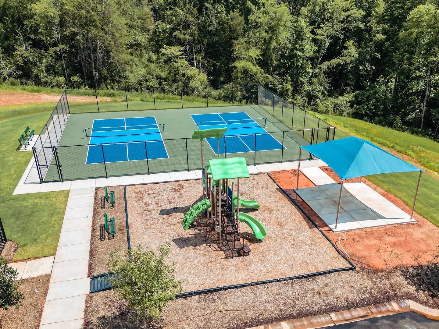 An aerial view of a tennis court and a playground.