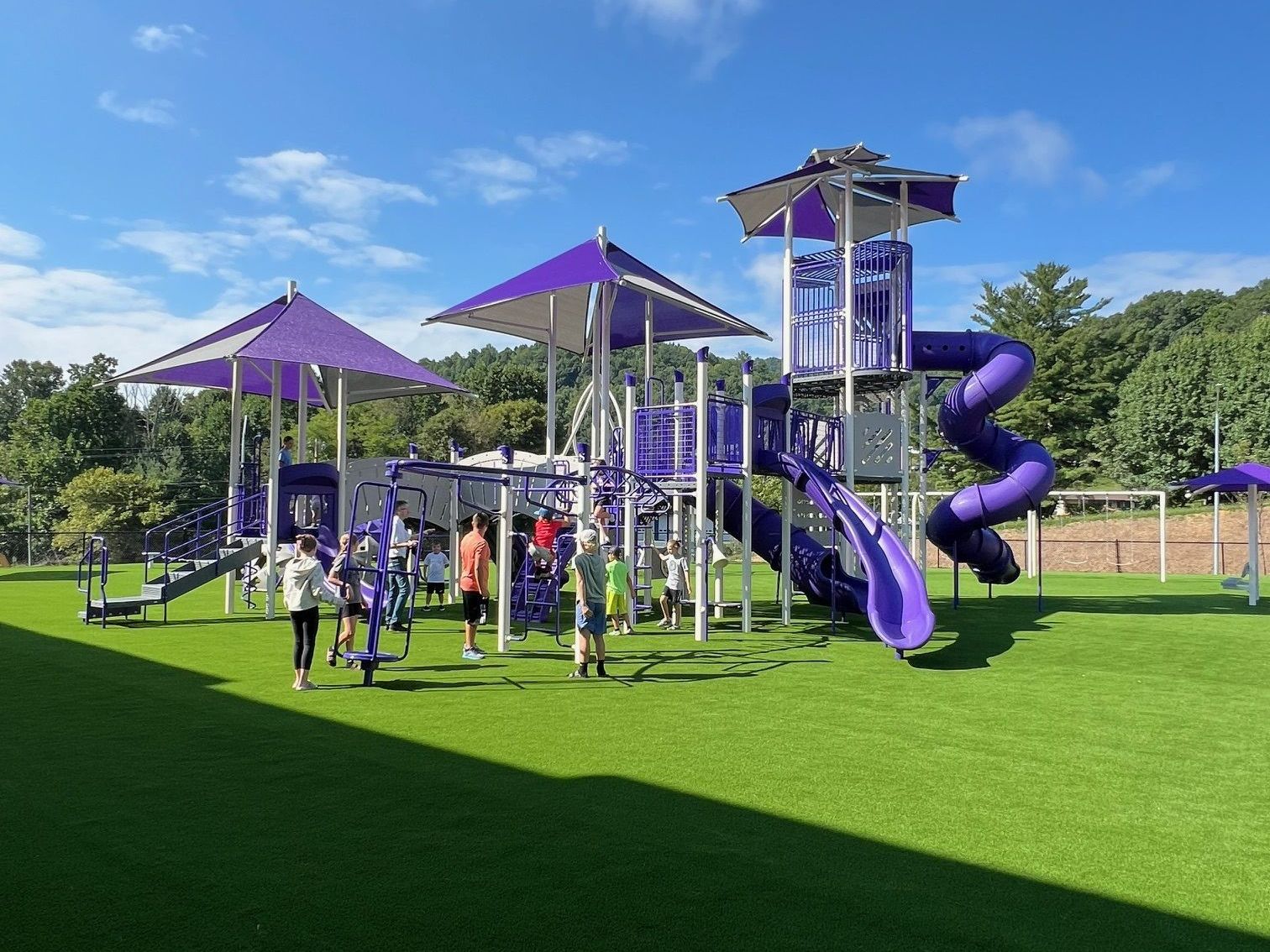 A group of children are playing on a purple playground.