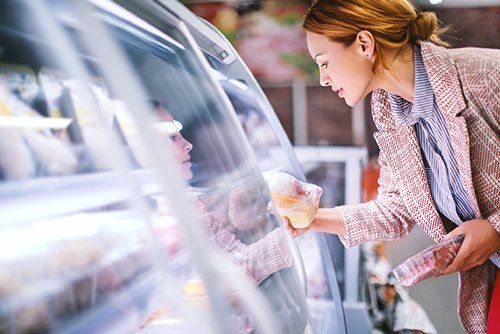 Industrial Refrigeration Contractor — Woman Getting Frozen Product Inside The Refrigerator in Gresham, OR