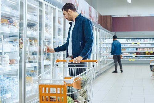 Apex Refrigeration — Man Checking Products Inside The Refrigerator in Gresham, OR