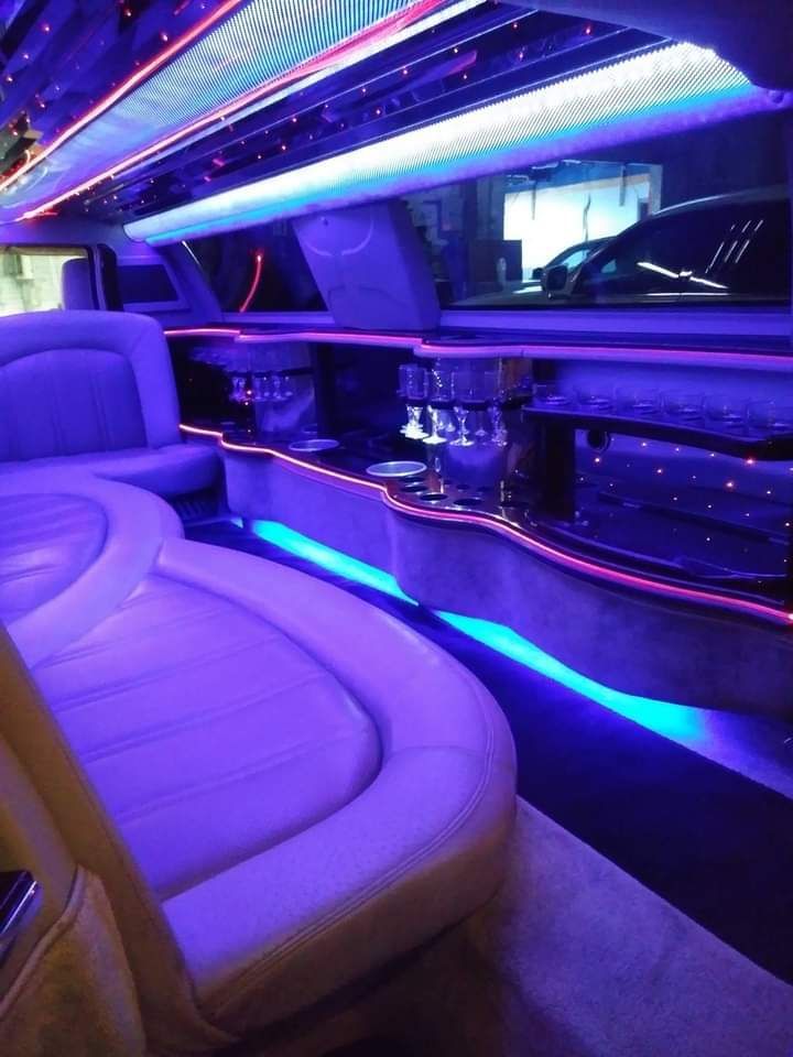 The inside of a limousine with purple and blue lights