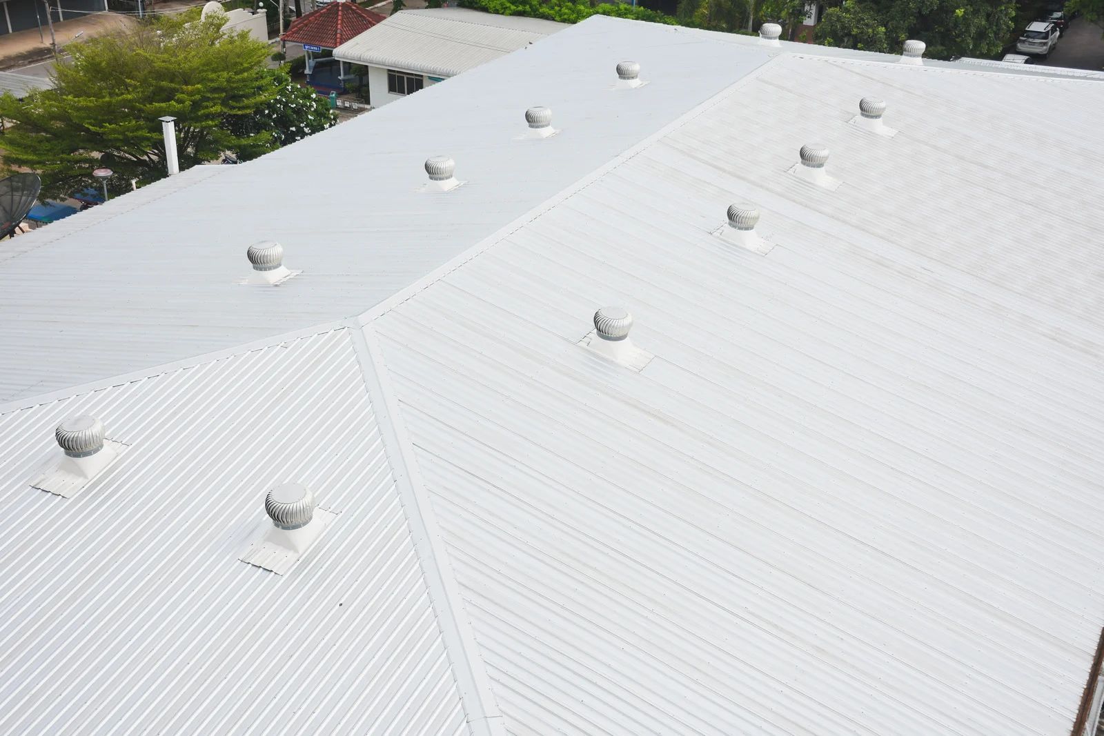 White metal roof with ventilation domes; sunlight.