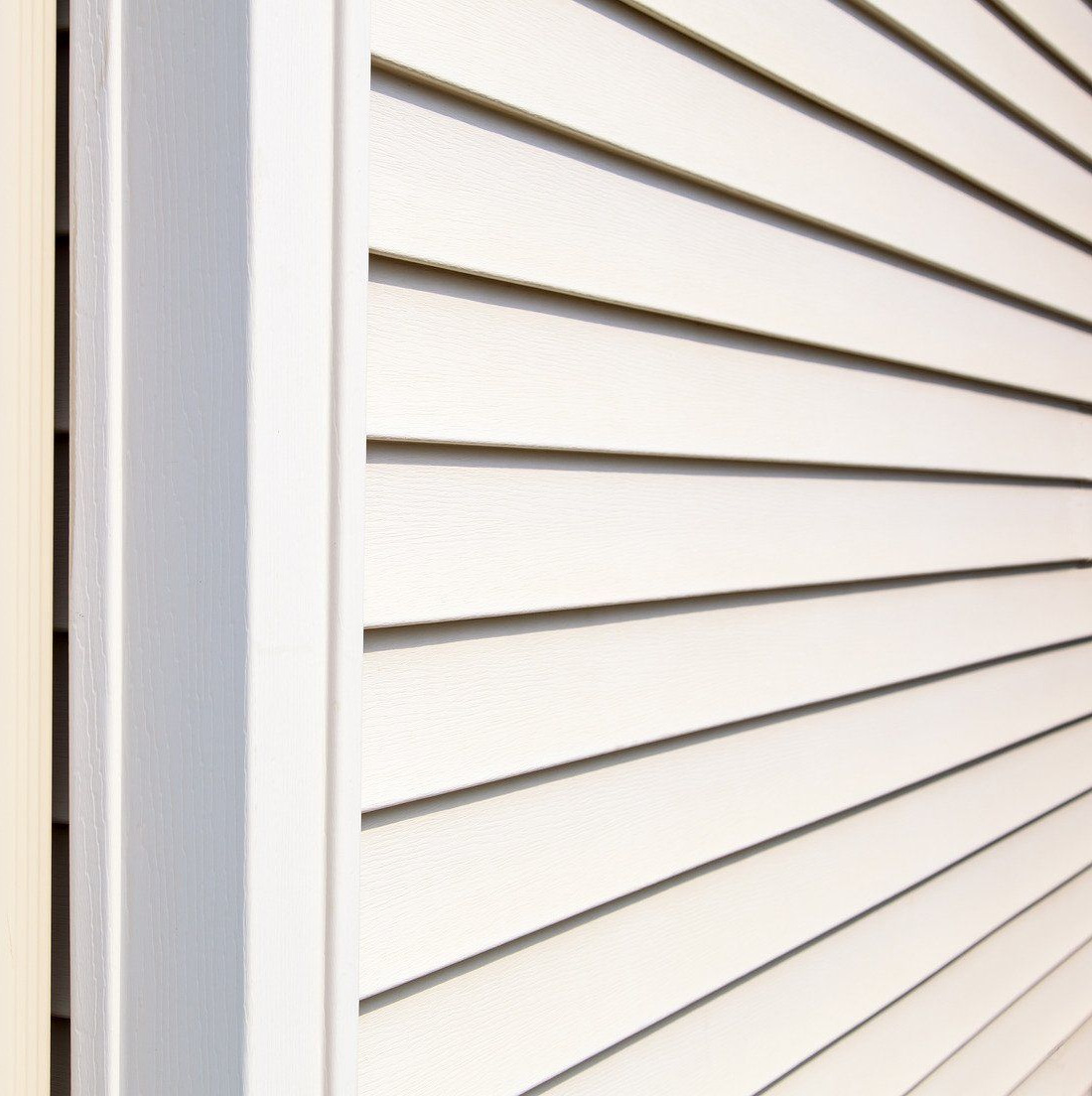 White vinyl siding and corner molding on a house exterior.