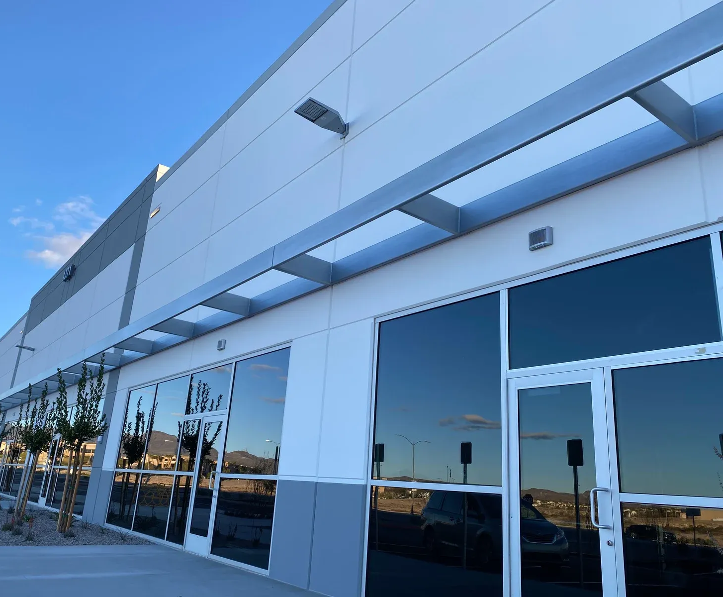 Modern, bright office space with cubicles, chairs, and windows. White and blue color scheme.