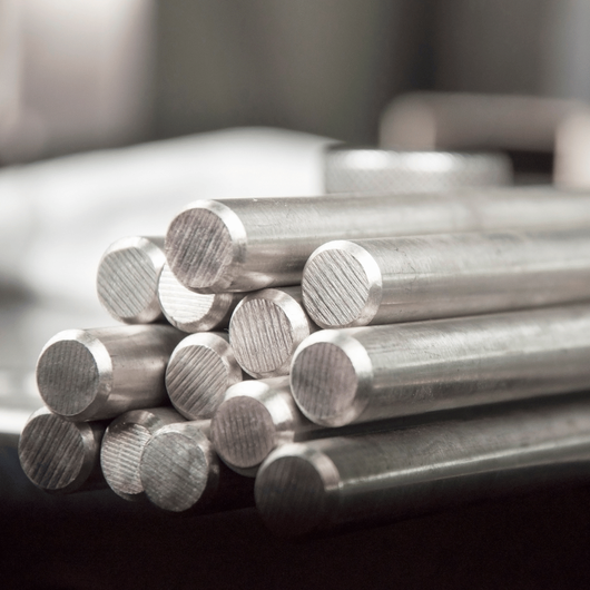 Palma Construction LLC | A pile of stainless steel bars stacked on top of each other on a table.