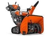 An orange and black snow blower on a white background.