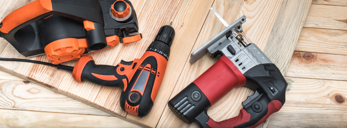 A group of tools are sitting on top of a wooden table.