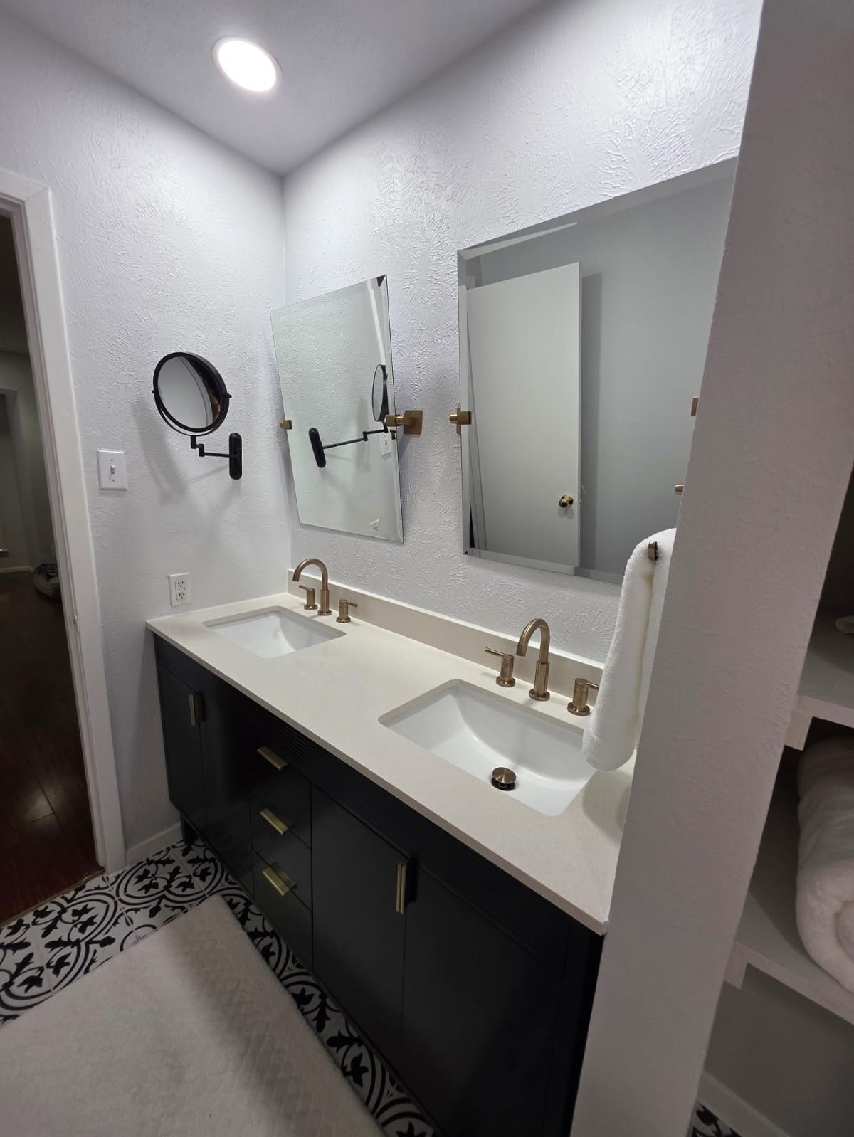 Modern bathroom vanity with double sinks, large mirror, and white and dark gray finishes