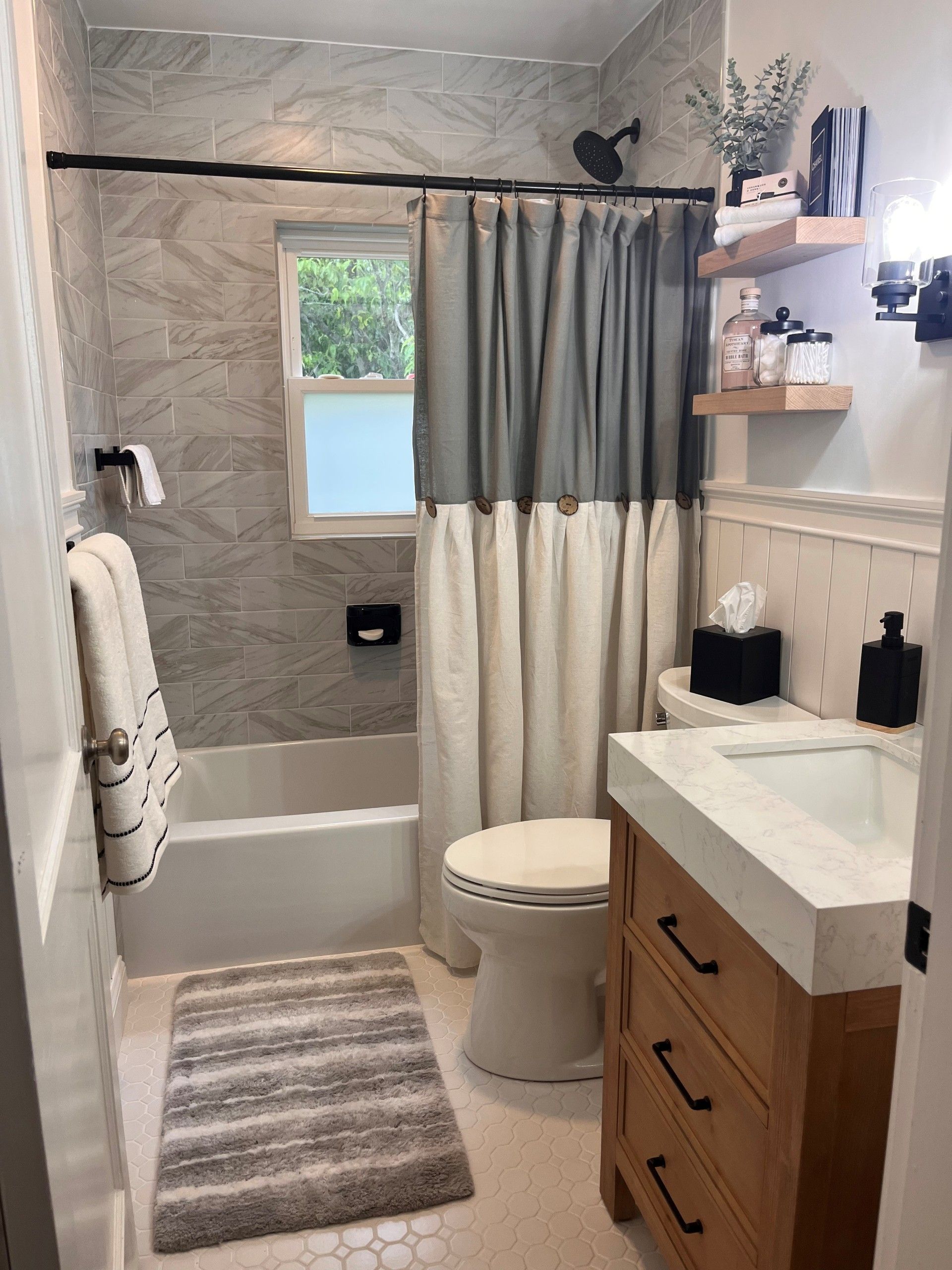 A bathroom with a toilet , sink , bathtub and shower curtain.