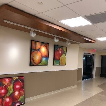 A hallway with paintings of fruit on the wall